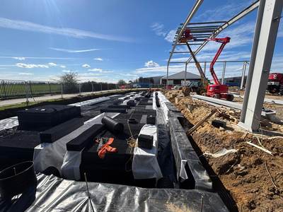 Geocellular attenuation crates laid on an impermeable membrane in the excavation, with twin-wall pipework connections