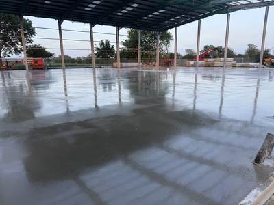 Freshly power-floated slab at dusk, its wet surface reflecting the frame and sky